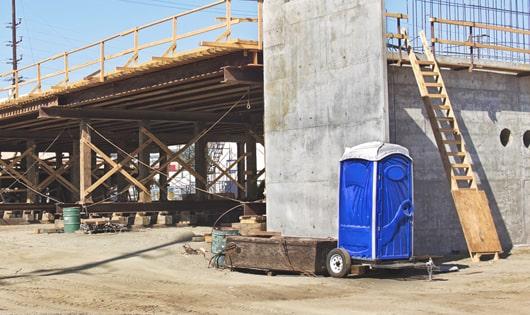 a row of sturdy porta potties at a job site